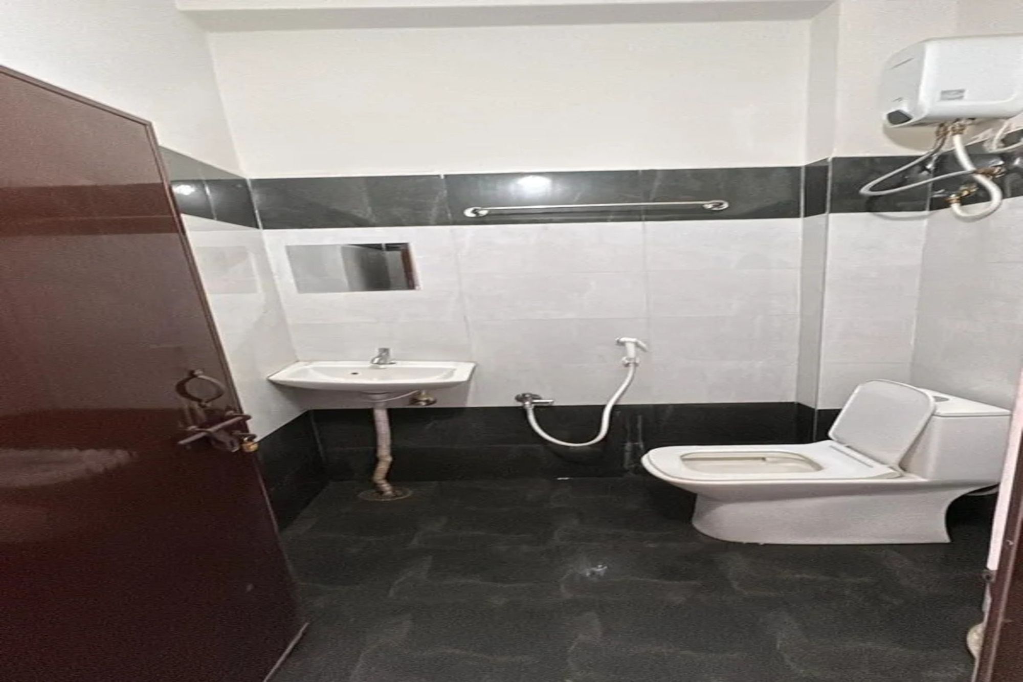 A small, compact bathroom with a toilet, sink, and shower.