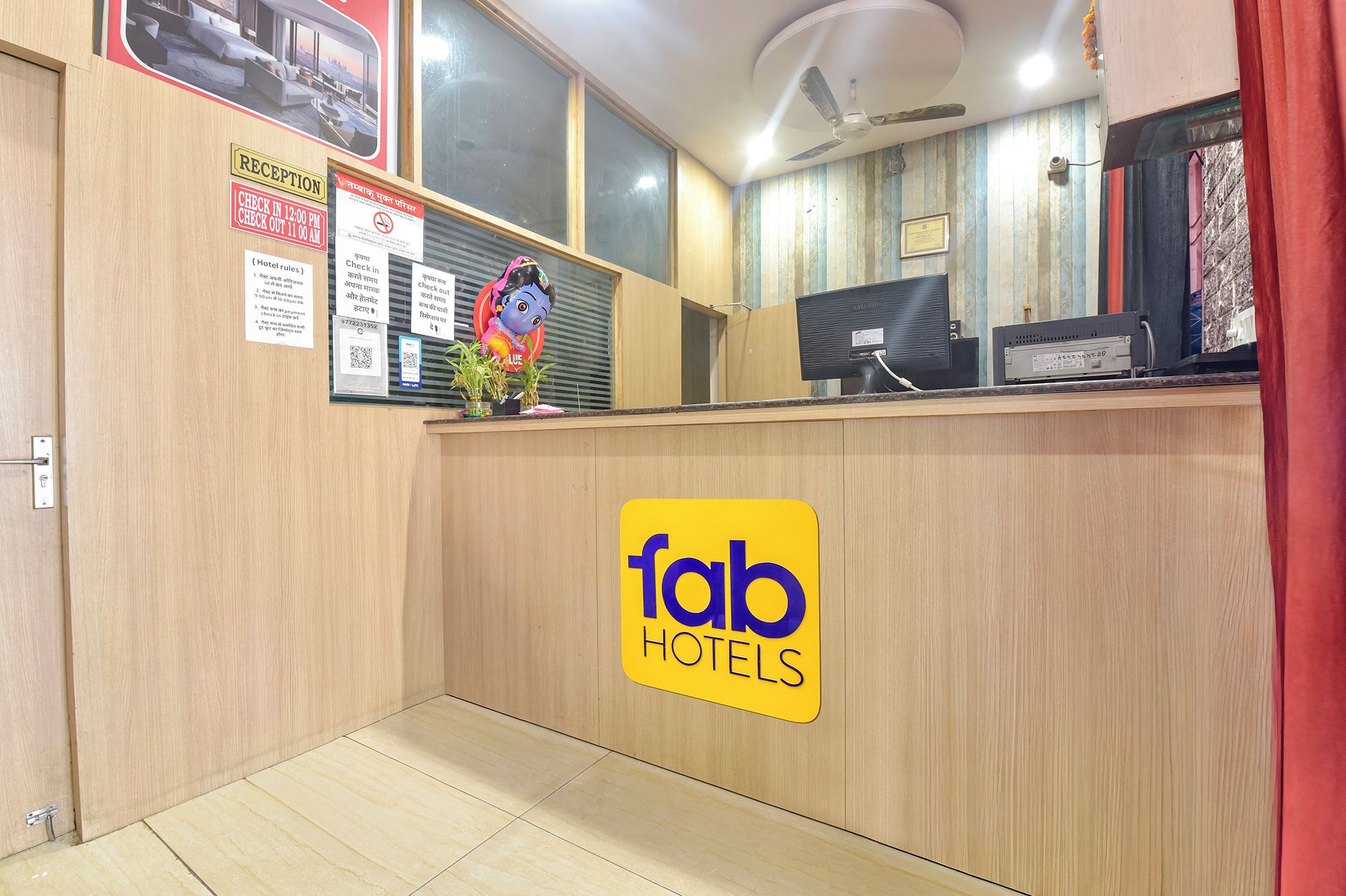 Una recepción de hotel con un cartel de registro de entrada/salida, un área de recepción y un mostrador de atención al cliente.