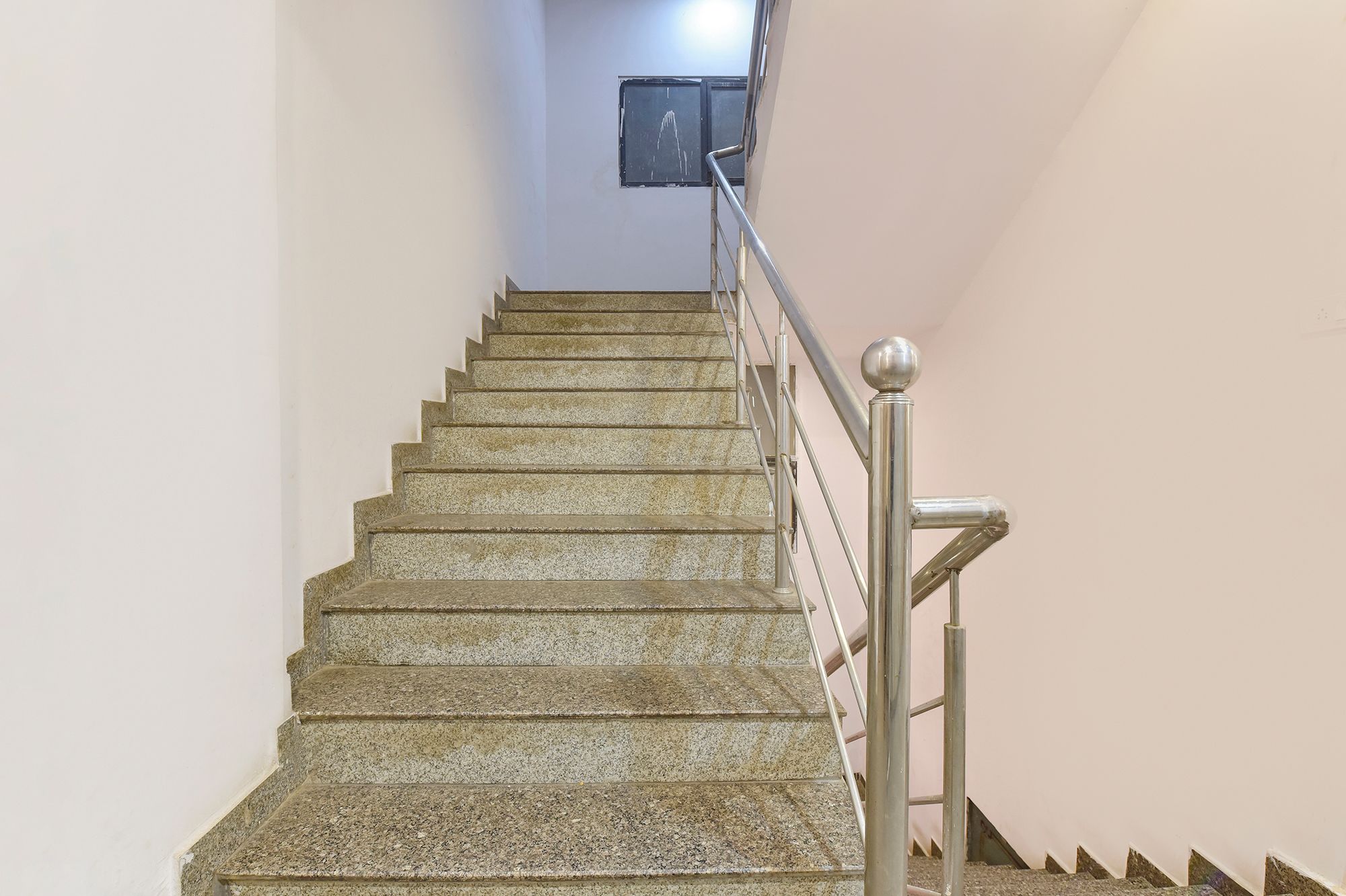 Una escalera con escalones de piedra y barandillas de metal.