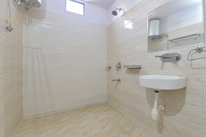 A bathroom with a shower, a sink, and a mirror. - FabHotel Sky Blue (Jaipur)