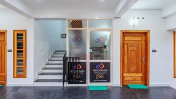 A reception area with a staircase, reception desk, and two wooden doors.