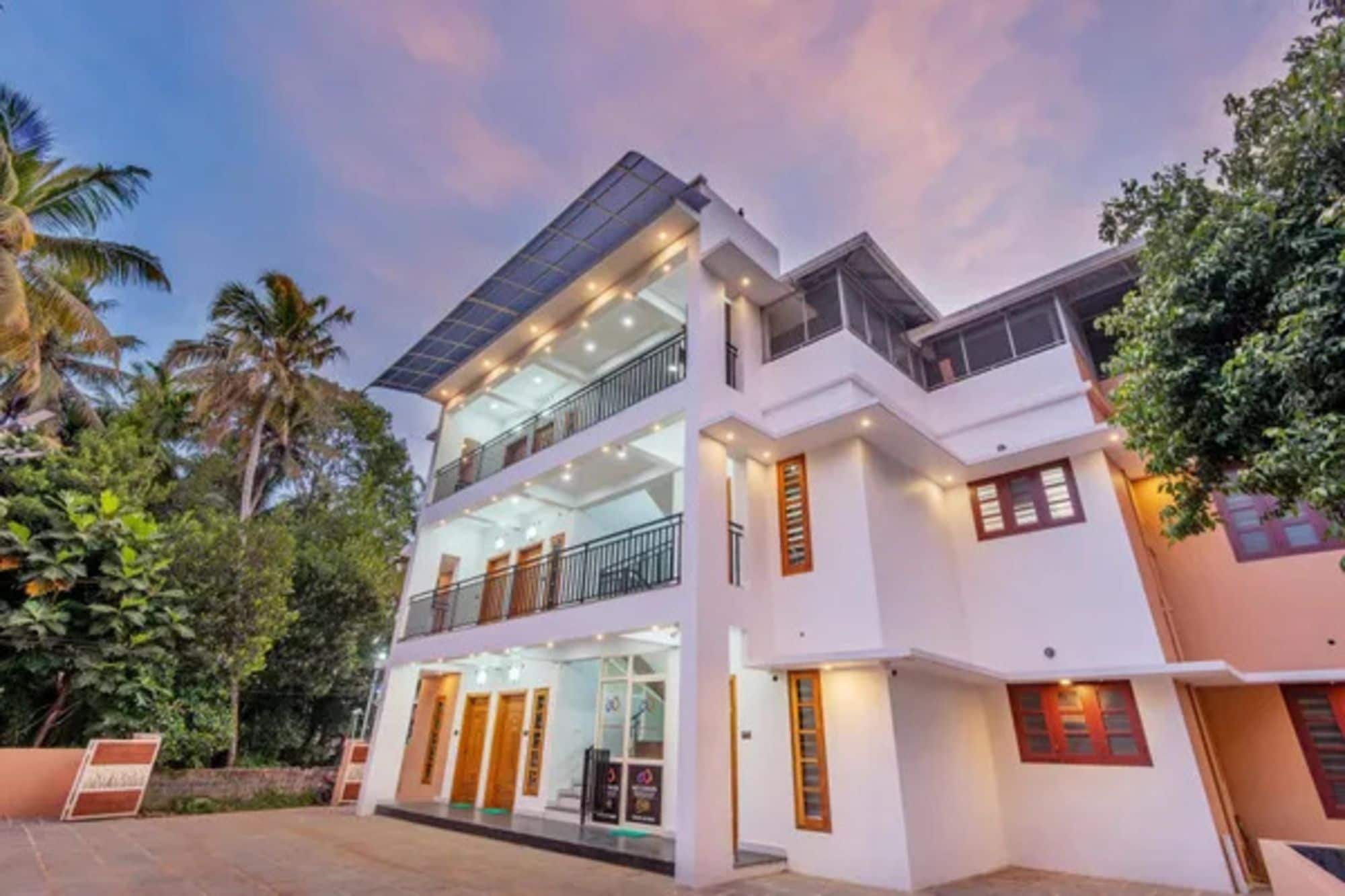 A two-story building with a flat roof, large windows, and a balcony.