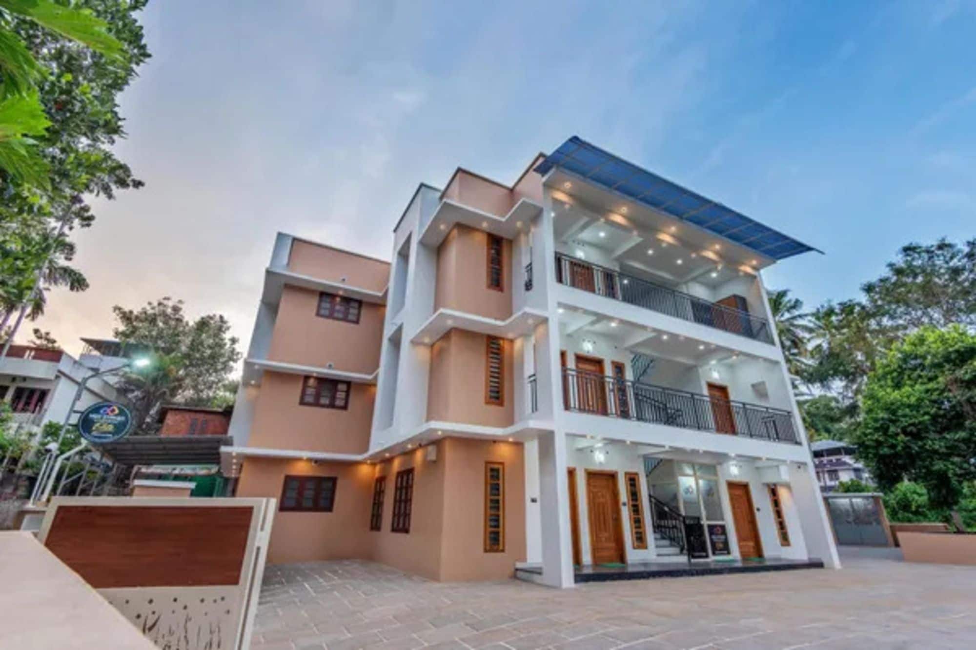 A multi-story residential building with a flat roof, balconies, and a gated entrance.