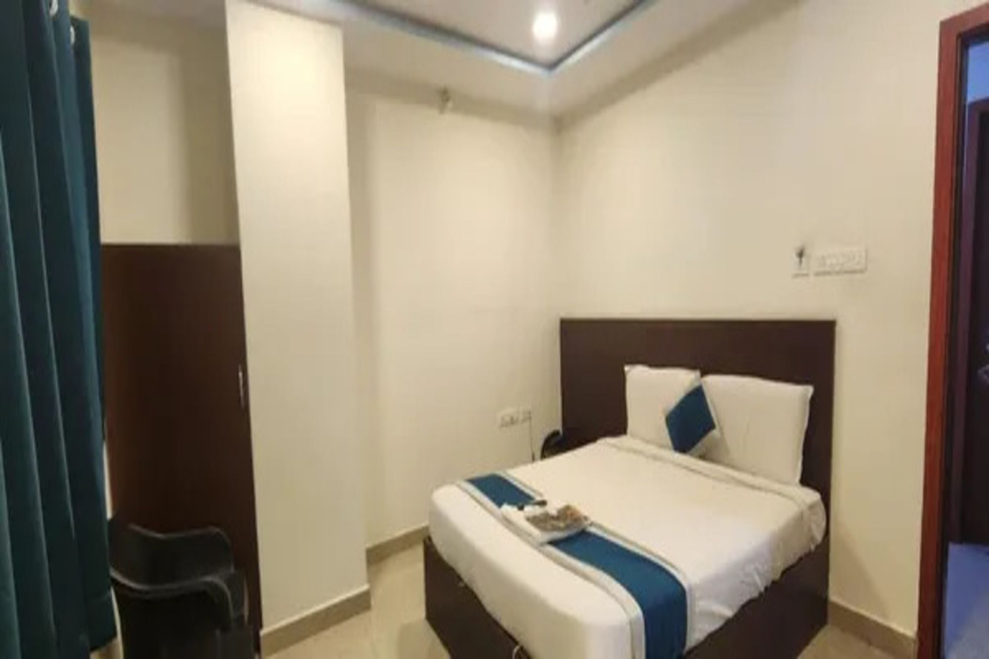 Ein Hotelzimmer mit einem Bett, einem Sessel und einer Tür.