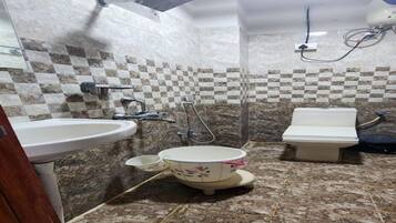 Une salle de bain avec un lavabo, des toilettes et une douche.