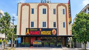 Un bâtiment avec une enseigne indiquant « Deficious Amandi House » et, en dessous, une enseigne pour un restaurant.