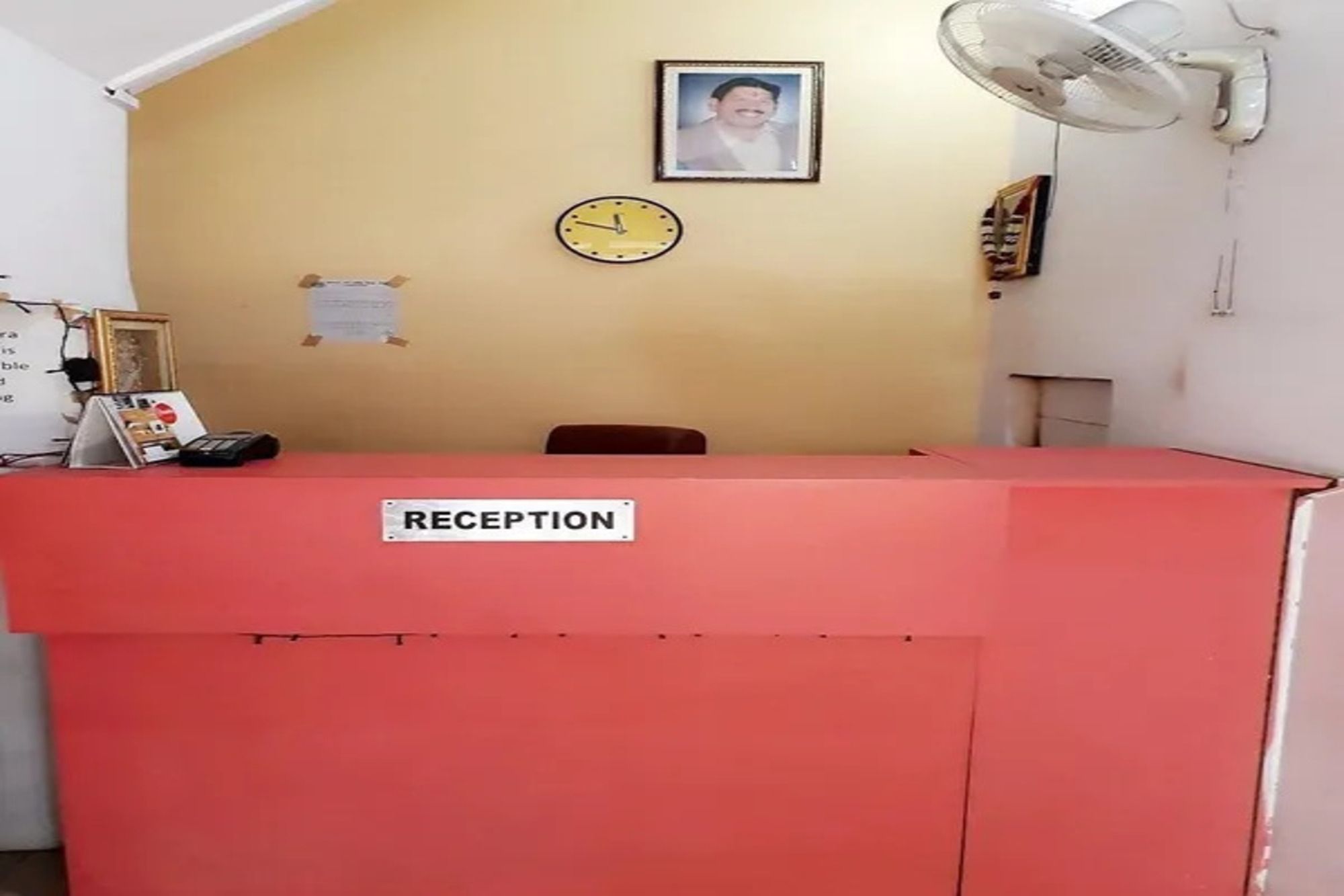 A reception desk with a sign, a clock, and a framed photo on the wall.