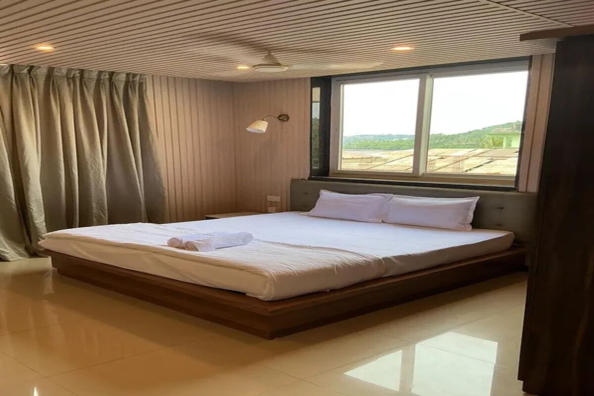 Habitación de hotel con una cama grande, una ventana y vistas al exterior.