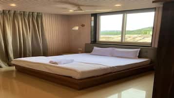 A hotel room with a large bed, a window, and a view of the outdoors.