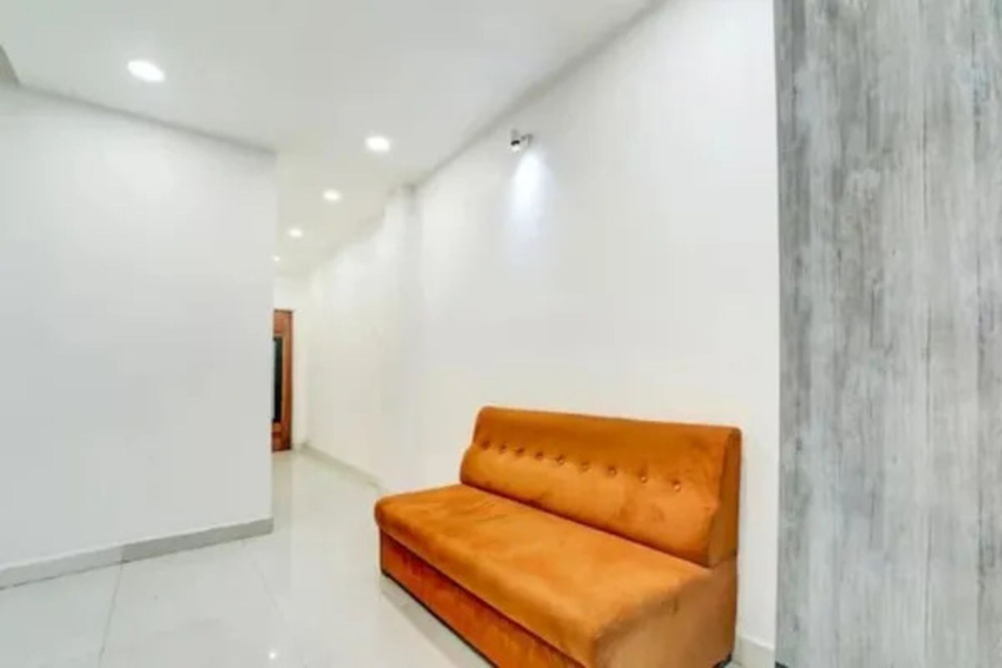 A hallway with a sofa and a wooden accent wall.