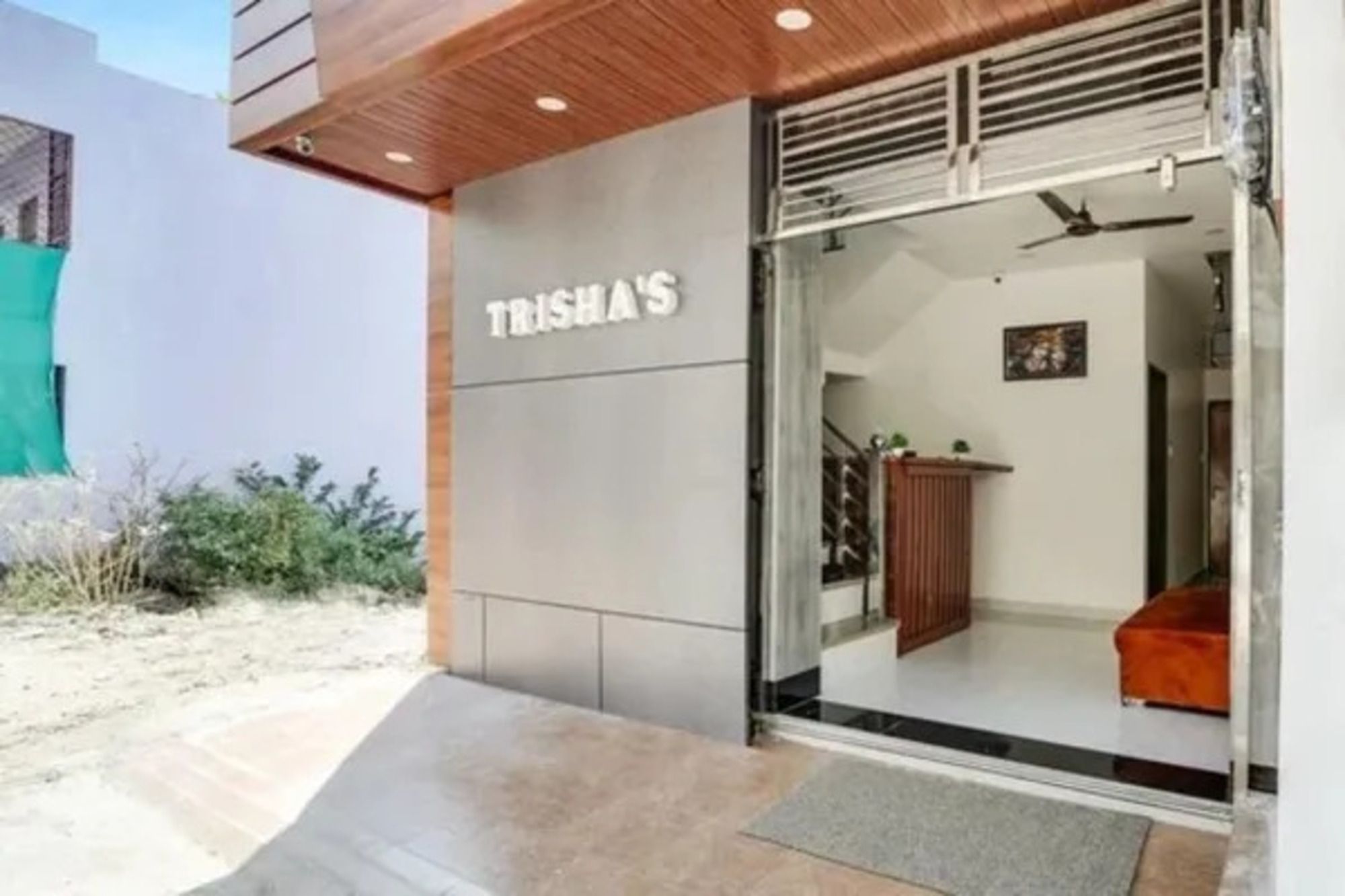 A building entrance with a sign that reads 'TRISHAS'.