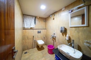 Un baño pequeño con inodoro, lavamanos y ducha.