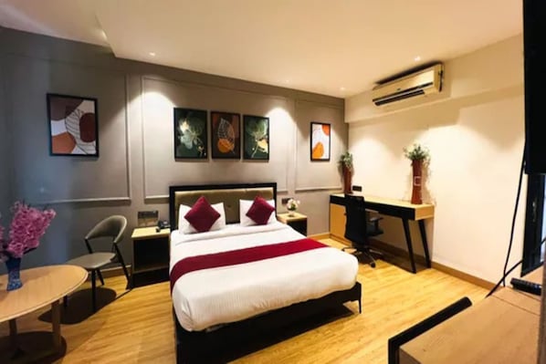 Una habitación de hotel con cama, mesitas de noche, escritorio y una silla.