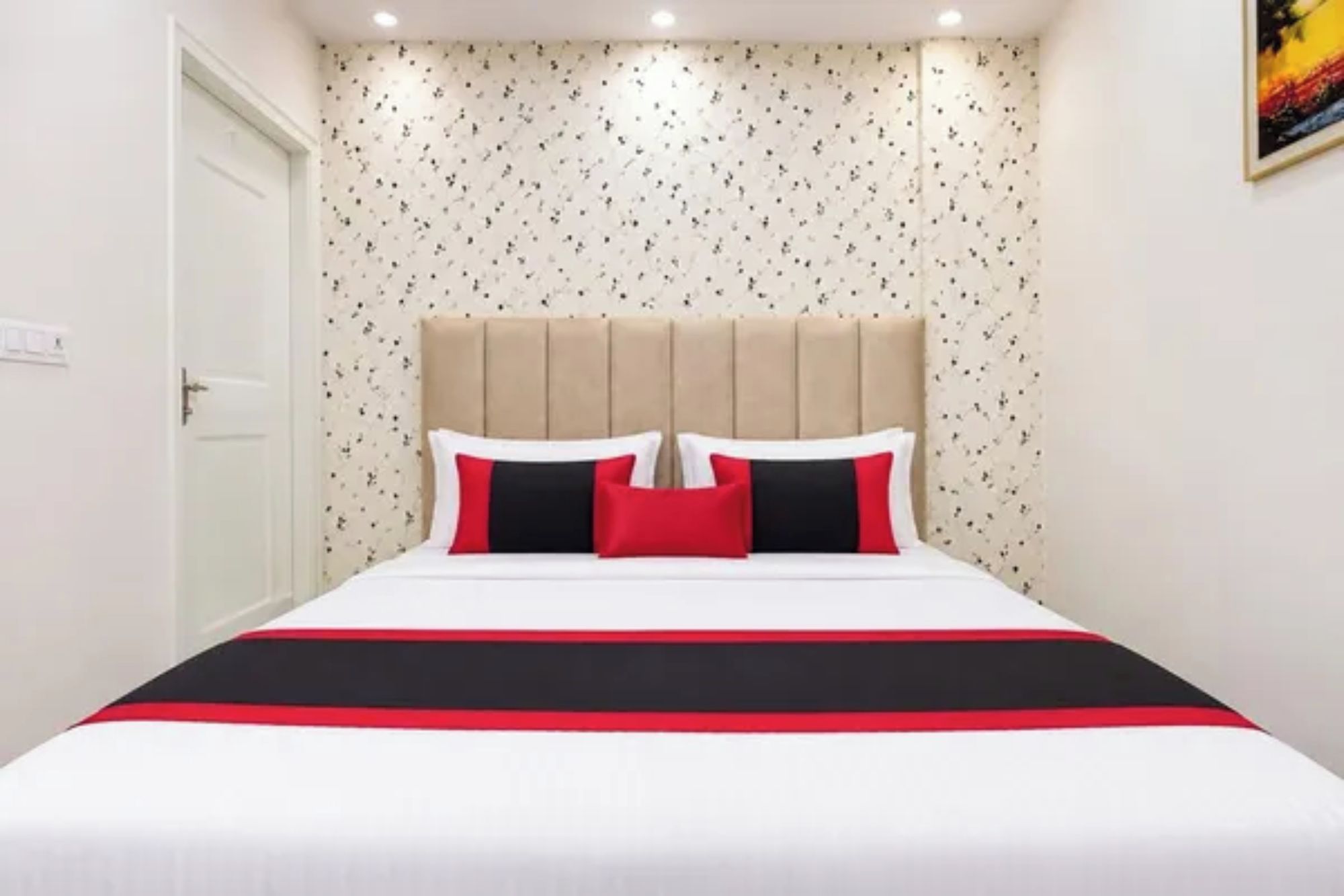 A bedroom with a bed, a headboard, and a door.