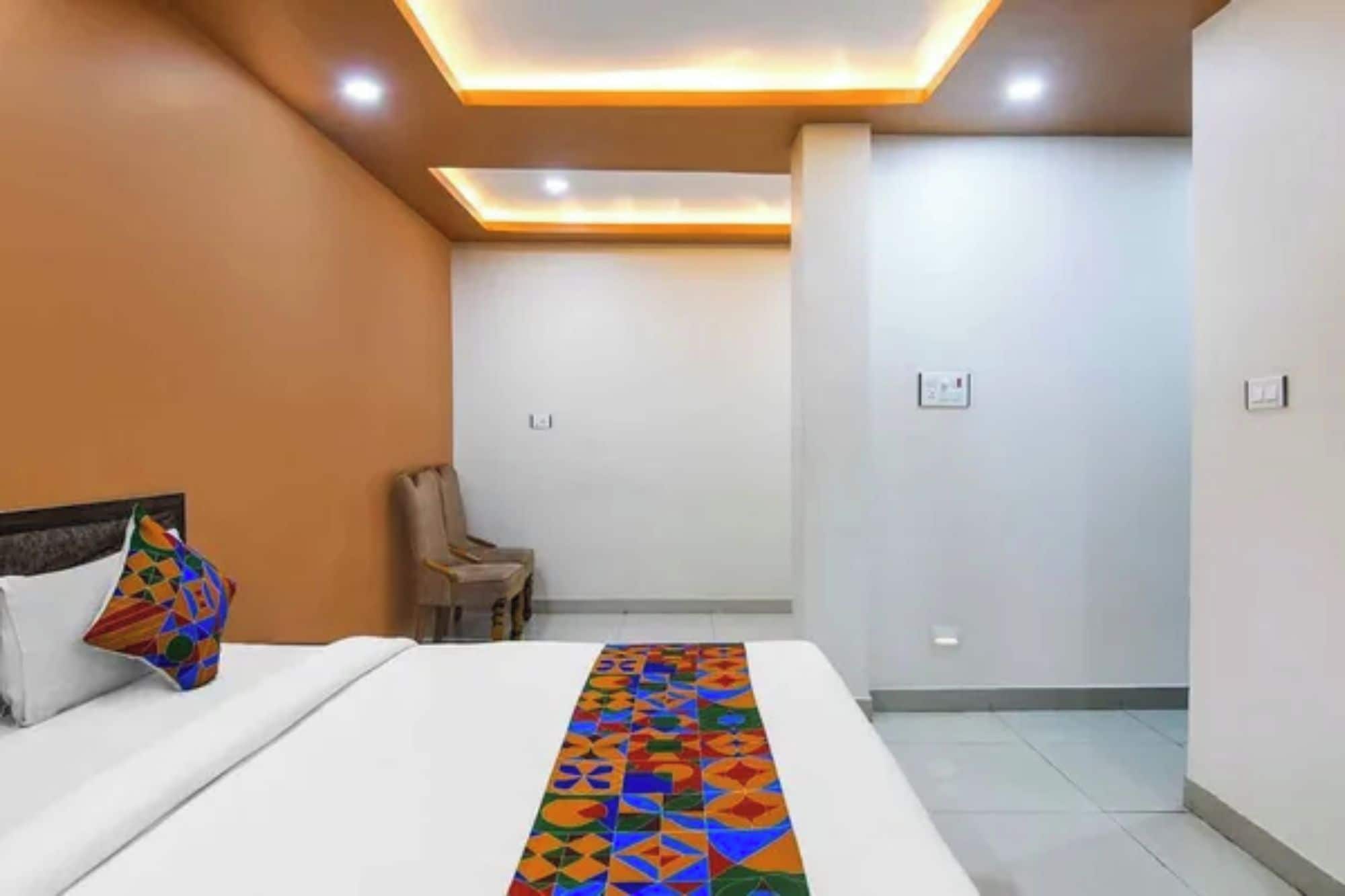 Una habitación de hotel con una cama, una silla y un corredor de cama estampado.