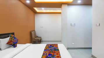 Una habitación de hotel con una cama, una silla y un corredor de cama estampado.
