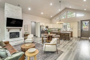 A spacious living room with a fireplace, a television mounted above it, and a seating area with a coffee table and chairs. - Golfer’s Oasis! Ponderosa Pine Retreat in Show Low (Show Low)
