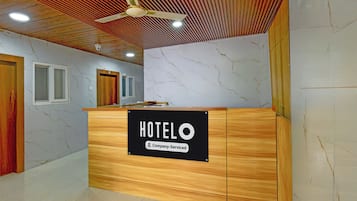 Un mostrador de recepción de hotel con un cartel que indica servicio corporativo.