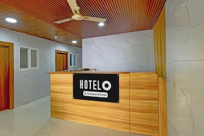 A hotel reception desk with a sign indicating it is company-serviced. - Hotel O Saibaba Temple Chintal (Hyderabad)