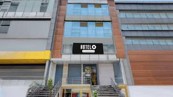 Un hotel con fachada moderna, un letrero llamativo y una escalera que conduce a la entrada.