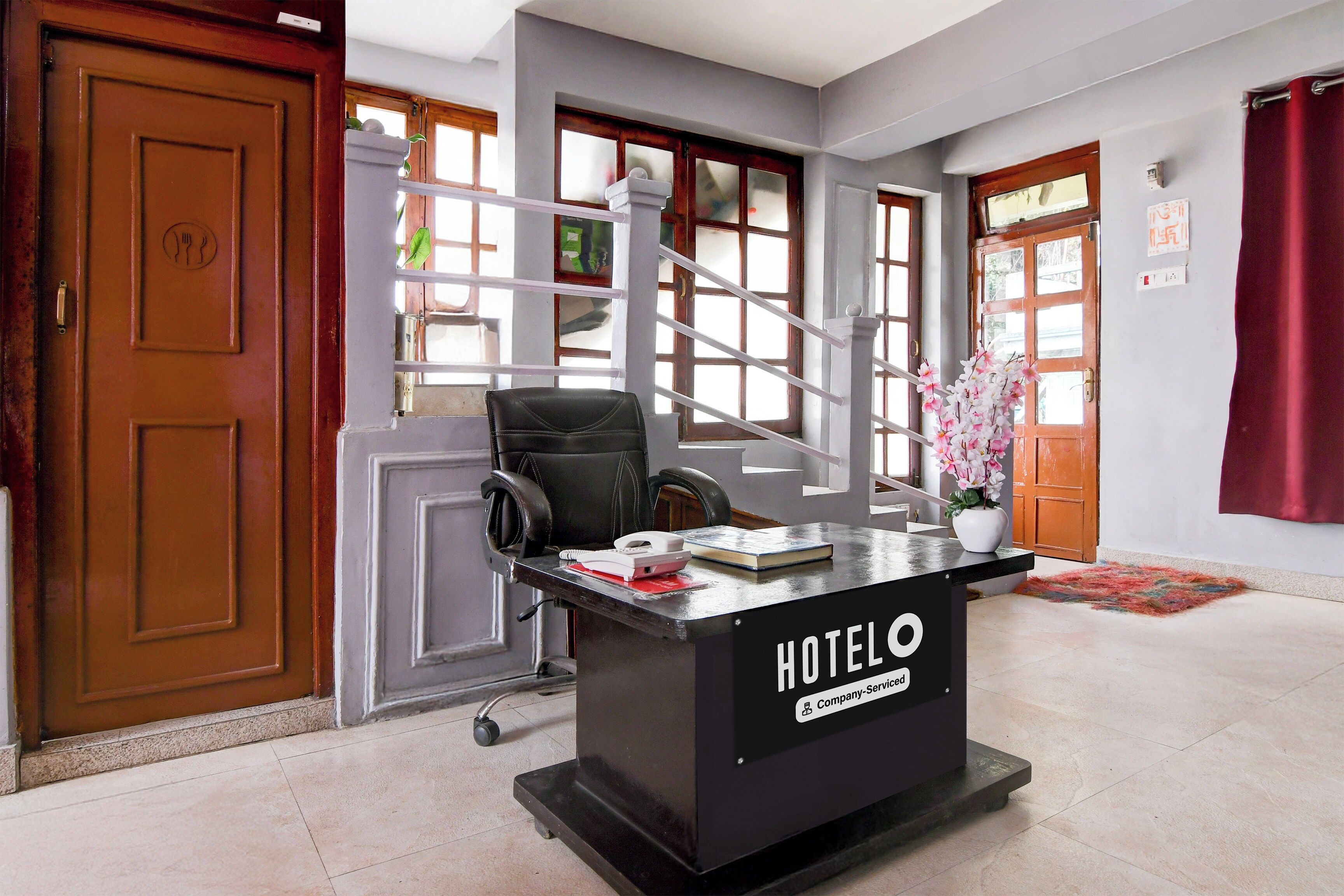 Un comptoir de réception d’hôtel avec une pancarte indiquant « SERVICE DE L’ENTREPRISE HÔTELIÈRE ».