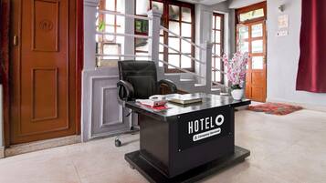 Un comptoir de réception d’hôtel avec une pancarte indiquant « SERVICE DE L’ENTREPRISE HÔTELIÈRE ».