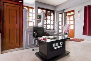 Un comptoir de réception d’hôtel avec une pancarte indiquant « SERVICE DE L’ENTREPRISE HÔTELIÈRE ».