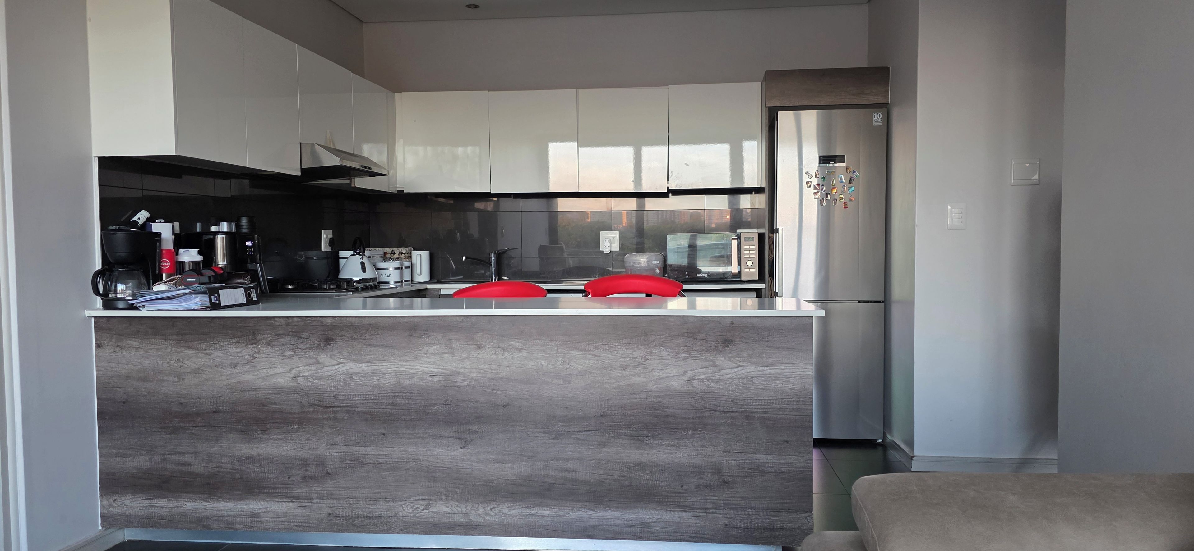 A modern kitchen with a central island, stainless steel appliances, and a large refrigerator.