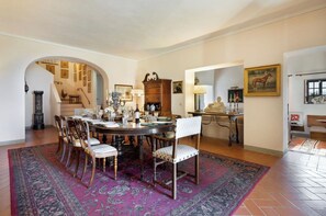 A dining area with a round table, chairs, and a patterned rug. - Villa Mare, Bolgheri by Geco Vacation Rentals (Bolgheri)