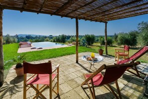 A covered outdoor area with a pool, lounge chairs, and a table with drinks. - Villa Mare, Bolgheri (Bolgheri)
