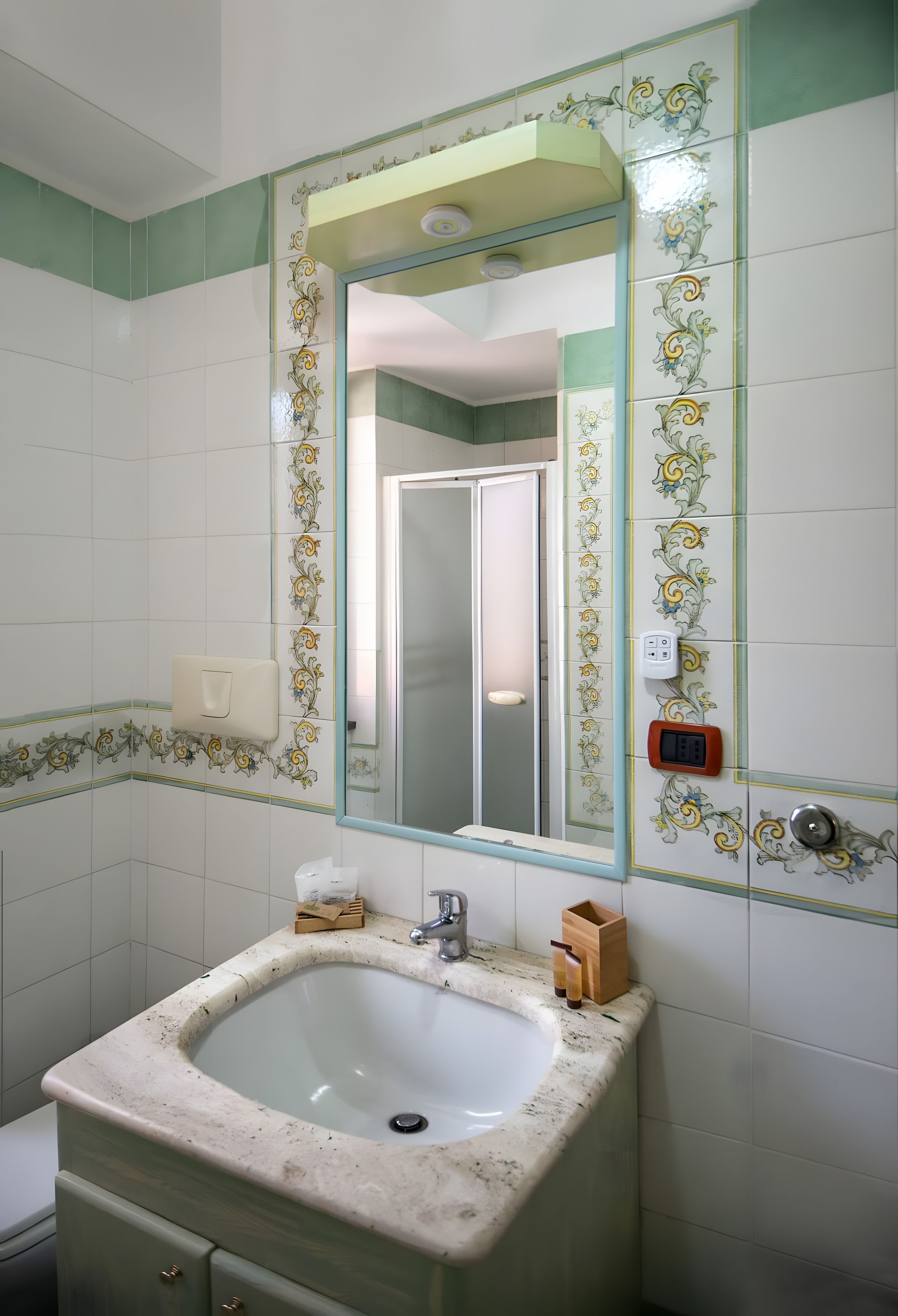 Ein Badezimmer mit Waschbecken, Spiegel und dekorativen Fliesen.