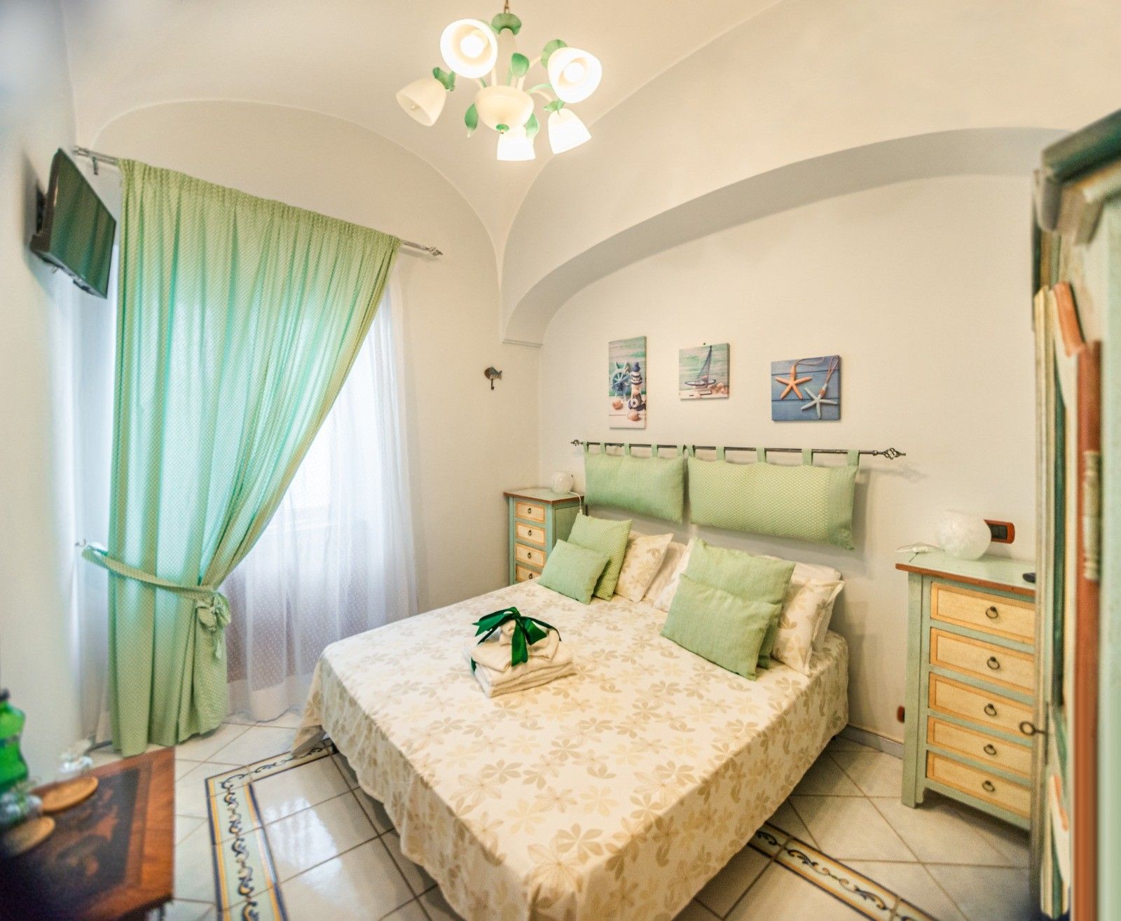 Un dormitorio con cama, mesita de noche, cómoda y candelabro.