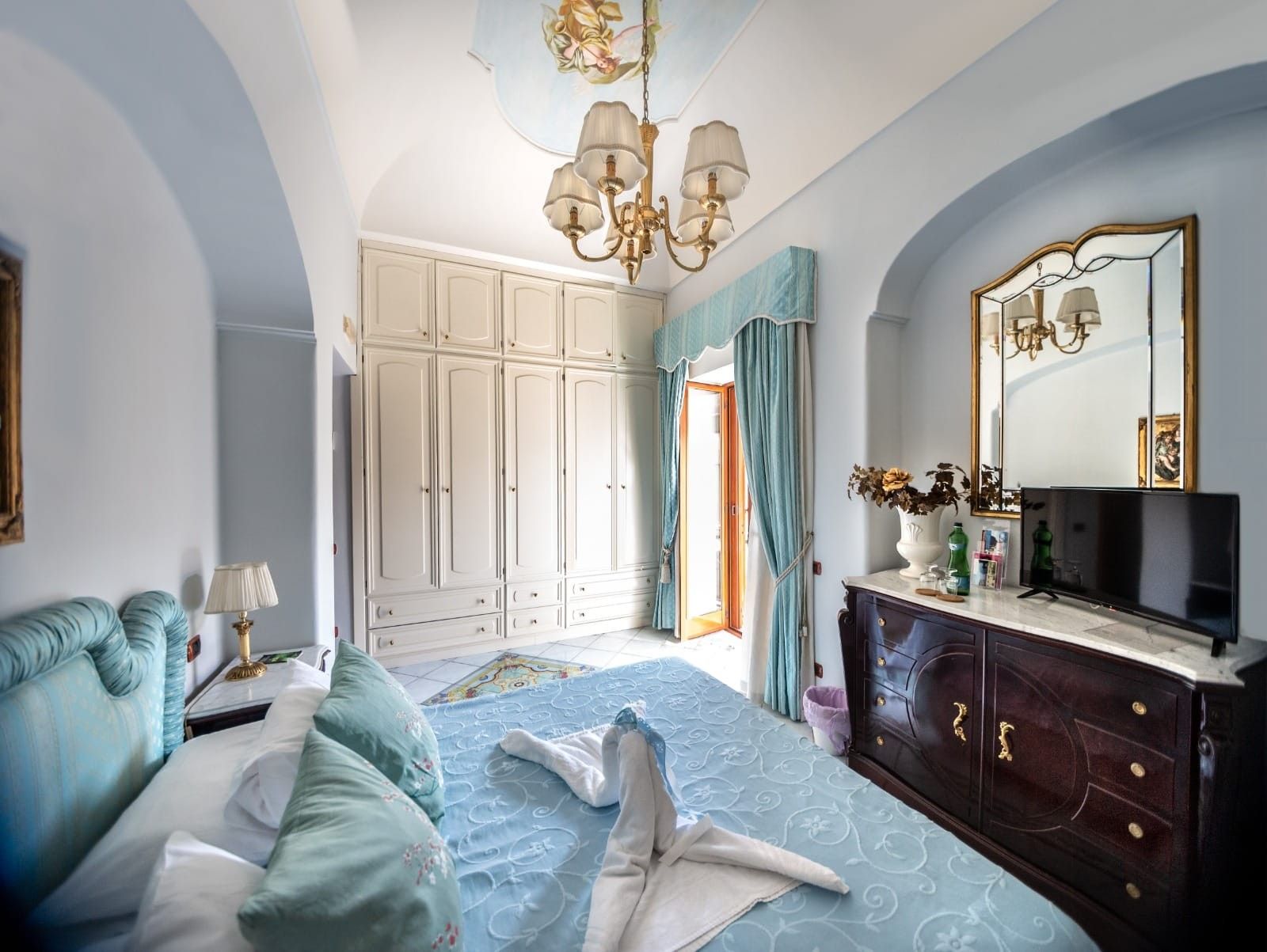 Un dormitorio con cama, cómoda, televisor y armario.