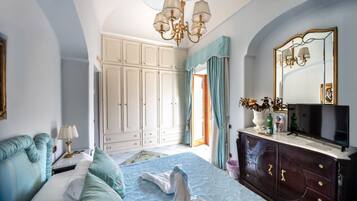 Un dormitorio con cama, cómoda, televisor y armario.