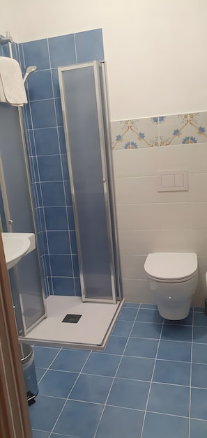 Ein Badezimmer mit Duschkabine, Toilette und Waschbecken.