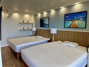 A hotel room with two beds, a wooden headboard, a mounted TV, and a wall-mounted shelf. - Renovated Ocean View 1 Bedroom Apartment @ The Ilikai Waikiki Beach, Honolulu (Honolulu)