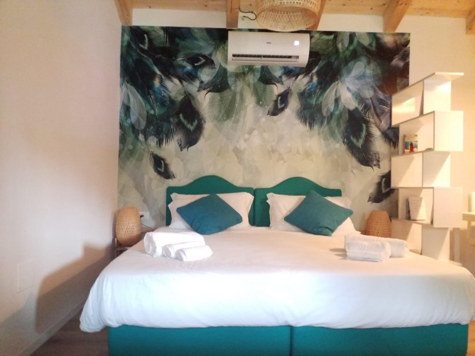 Una camera da letto con un letto, un condizionatore d'aria a parete e una libreria.