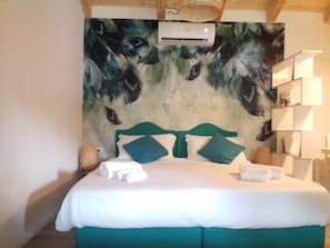 Una camera da letto con un letto, un condizionatore d'aria a parete e una libreria.