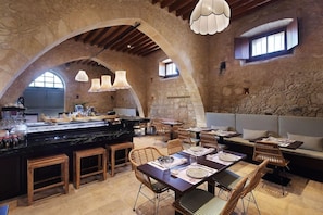 A restaurant with stone walls, wooden furniture, and pendant lighting. - Polis 1907 (Polis)