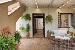 A spacious indoor area with a staircase, a sofa, and various potted plants. - Stunning villa with private pool in Graniti, near Taormina – DiCasaInSicilia (Graniti)