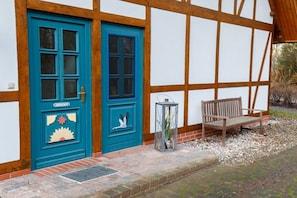 Ein Gebäude mit einer blauen Tür, einer Bank und einem Laternen.