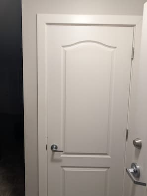 A white door with a silver handle and a keyhole lock. - Spacious Yorkton Apartment (Yorkton)