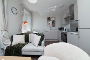 A compact living space with a sofa, a dining area, and a kitchenette. - Sovereign Quay 1BR Apartment | Old Town Hull (Kingston upon Hull)
