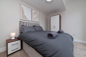 A bedroom with a bed, a nightstand, a lamp, and a wardrobe. - 1-Bedroom Stay | Hull Old Town & Museums Quarter (Kingston upon Hull)