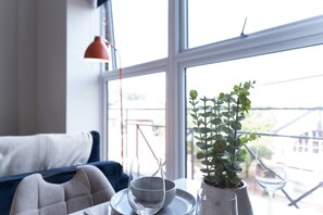 A room with a sofa, a table with a glass bowl and a wine glass, and a potted plant. - 1-Bedroom Stay | Hull Old Town & Museums Quarter (Kingston upon Hull)