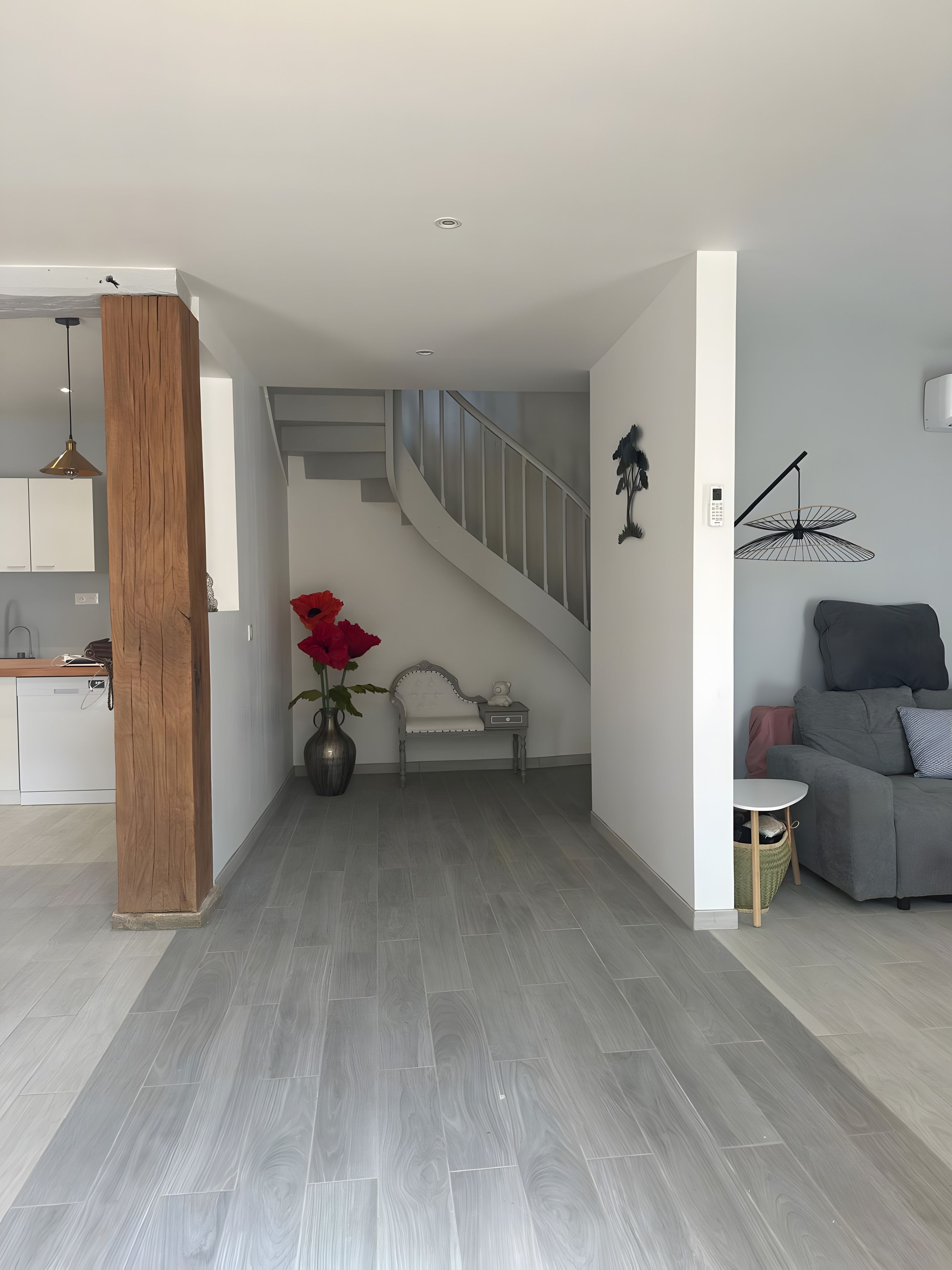 A modern interior with a staircase, a dining area, and a living space.