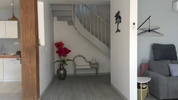 A modern interior with a staircase, a dining area, and a living space.