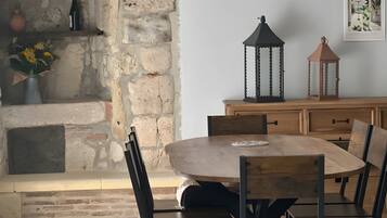 A dining area with a stone wall, wooden table, and chairs.