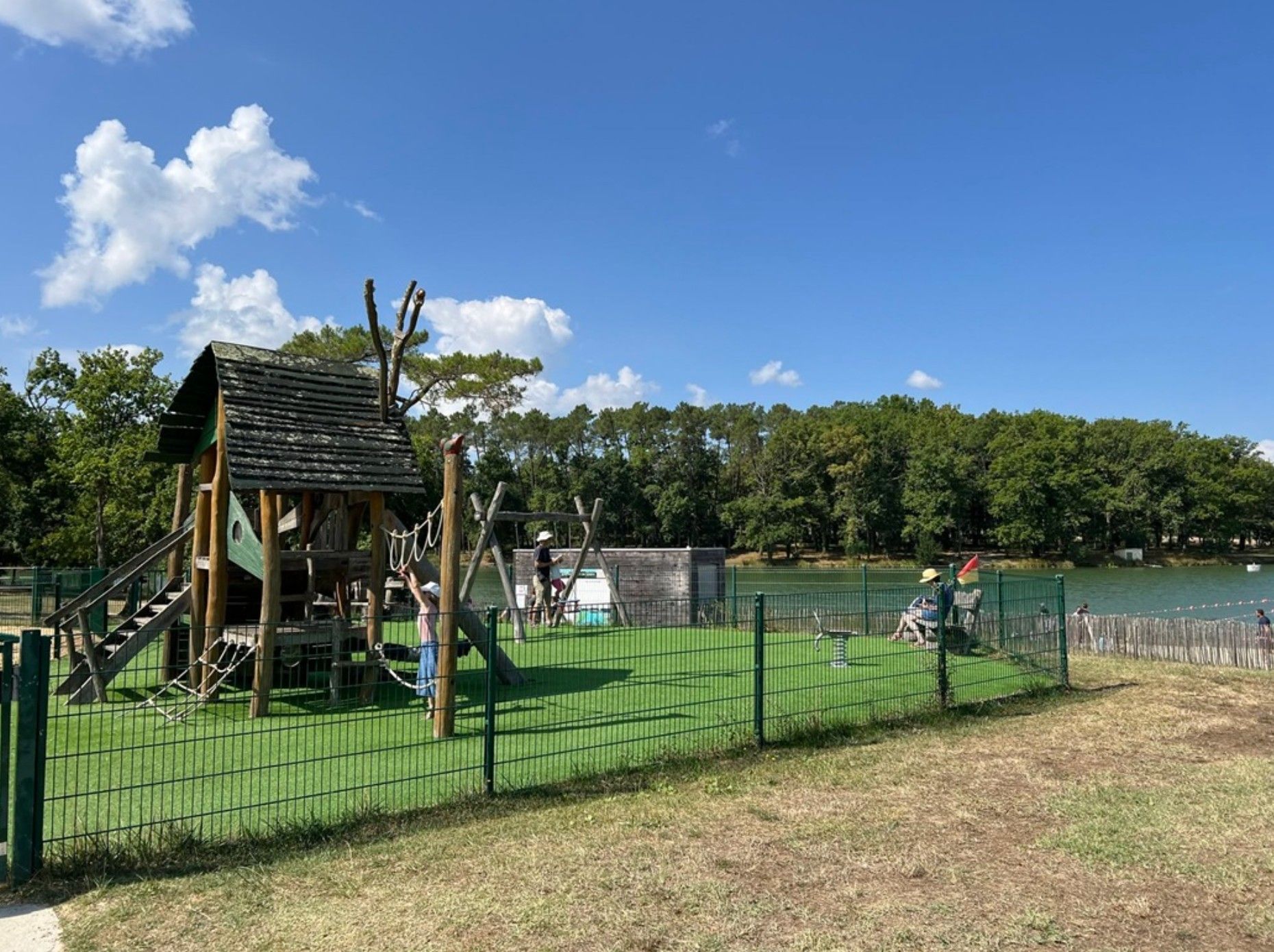 A playground with a climbing structure and a fenced area.