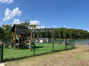 A playground with a climbing structure and a fenced area.
